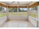 Enclosed sunroom featuring tile floors, multiple windows overlooking a grassy yard, and window shades at 790 Chelsea Way, Lake Wales, FL 33853