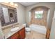 Updated bathroom with granite countertop, tub, and natural light at 843 Christina Chase Dr, Lakeland, FL 33813
