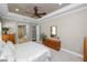 Bedroom featuring neutral colors, tray ceilings, ceiling fan and ensuite bath at 843 Christina Chase Dr, Lakeland, FL 33813