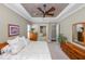Bedroom featuring neutral colors, tray ceilings, ceiling fan and ensuite bath at 843 Christina Chase Dr, Lakeland, FL 33813