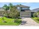 Charming home featuring a manicured lawn, lush landscaping, and an attached two-car garage at 843 Christina Chase Dr, Lakeland, FL 33813