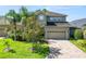 Two-story home featuring lush landscaping, a paver driveway, and a warm, inviting facade at 843 Christina Chase Dr, Lakeland, FL 33813
