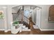 Charming hallway featuring wood floors, staircase, and decorative wrought iron banister, leading to the home's upper level at 843 Christina Chase Dr, Lakeland, FL 33813