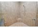 A neutral toned, tiled shower features a showerhead with a travertine corner shelf for added convenience at 843 Christina Chase Dr, Lakeland, FL 33813