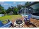 Cozy backyard with a fire pit, seating, and views of the screened-in pool area at 8760 Plantation Ridge Blvd, Lakeland, FL 33809