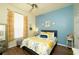 Well-lit bedroom with blue accent wall, queen-sized bed, and ample natural light from a large window at 8760 Plantation Ridge Blvd, Lakeland, FL 33809