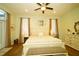 Cozy bedroom showcasing hardwood floors, stylish white furniture, and natural light from two windows at 8760 Plantation Ridge Blvd, Lakeland, FL 33809