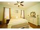 Well-lit bedroom showcasing hardwood floors, a dresser, and natural light from two windows at 8760 Plantation Ridge Blvd, Lakeland, FL 33809