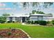 Charming single-story home featuring lush lawn, mature plantings, and a welcoming walkway to the front door at 8760 Plantation Ridge Blvd, Lakeland, FL 33809