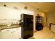 Spacious kitchen features a black refrigerator, white cabinets, and tiled floors for easy maintenance at 8760 Plantation Ridge Blvd, Lakeland, FL 33809