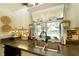Kitchen sink beneath a window overlooking the pool, featuring stylish decor and tiled backsplash at 8760 Plantation Ridge Blvd, Lakeland, FL 33809