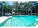 Sparkling pool with a screened enclosure, surrounded by lounge chairs and lush greenery at 8760 Plantation Ridge Blvd, Lakeland, FL 33809