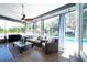 Bright sunroom featuring comfortable seating, a ceiling fan, and an outdoor pool view at 8760 Plantation Ridge Blvd, Lakeland, FL 33809