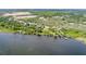 Aerial of a lakefront property with a private dock, surrounded by lush greenery and serene views at 9093 S Bay Dr, Haines City, FL 33844
