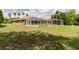 Back exterior of house with an in-ground pool beyond the screened patio, and lush green lawn at 9093 S Bay Dr, Haines City, FL 33844