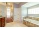 Bathroom featuring a soaking tub with marble surround, linen closet, and a doorway at 9093 S Bay Dr, Haines City, FL 33844