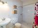 Well-lit bathroom featuring a pedestal sink, toilet, and shower with gray tile and glass door at 9093 S Bay Dr, Haines City, FL 33844