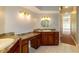 Well-lit bathroom showcasing dual sinks with granite countertops, vanity area, and hallway access at 9093 S Bay Dr, Haines City, FL 33844