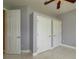 Bedroom featuring multiple closet doors, neutral paint, and tile flooring at 9093 S Bay Dr, Haines City, FL 33844