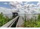 Scenic view of a private dock extending into the calm lake, perfect for relaxing or fishing at 9093 S Bay Dr, Haines City, FL 33844