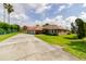 Beautiful house with an attached three-car garage, a spacious driveway, and lush green landscaping at 9093 S Bay Dr, Haines City, FL 33844