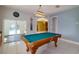 Elegant game room with a classic billiard table, tiled floors, and easy access to outdoor spaces at 9093 S Bay Dr, Haines City, FL 33844