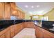 Open kitchen features sleek black granite countertops, wood cabinets, and tile flooring at 9093 S Bay Dr, Haines City, FL 33844