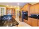Kitchen with black granite countertops, wood cabinets, and stainless steel refrigerator at 9093 S Bay Dr, Haines City, FL 33844
