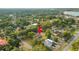 An aerial view shows the home nestled among mature trees in a quiet, established neighborhood near a lake at 911 S Missouri Ave, Lakeland, FL 33803
