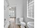 Bathroom featuring a tub and shower combination, with an adjacent toilet and unique glass block window at 911 S Missouri Ave, Lakeland, FL 33803