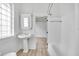All-white bathroom with pedestal sink, medicine cabinet, and tub/shower combination at 911 S Missouri Ave, Lakeland, FL 33803