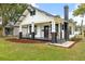 Exterior view of a charming bungalow featuring a well-maintained lawn, dark trim and inviting front porch at 911 S Missouri Ave, Lakeland, FL 33803