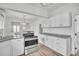 Bright kitchen featuring white cabinetry, stainless steel appliances, and granite countertops at 911 S Missouri Ave, Lakeland, FL 33803
