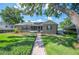 Charming home with a screened porch, well-manicured lawn, and inviting brick walkway at 916 Woodward St, Lakeland, FL 33803