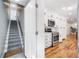 Split image of carpeted stairs, and a kitchen with white cabinets and stainless steel appliances at 916 Woodward St, Lakeland, FL 33803