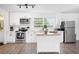 Modern kitchen features white cabinets, stainless steel appliances, an island, and lots of natural light at 916 Woodward St, Lakeland, FL 33803