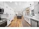 Spacious kitchen boasts white cabinets, stainless steel appliances, island, and hardwood floors at 916 Woodward St, Lakeland, FL 33803