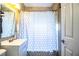 Well-lit bathroom featuring a single sink vanity, tile accents, and a shower-tub combo with a patterned curtain at 960 Lila St, Bartow, FL 33830