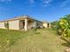 The spacious backyard features lush grass, landscaping, and a covered patio at 120 Grove Branch Rd, Winter Haven, FL 33880