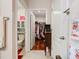 Hallway view of bathroom, walk-in closet, hardwood floors, and a cabinet at 120 Grove Branch Rd, Winter Haven, FL 33880