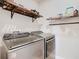 Laundry room with modern front-load washer and dryer, plus storage shelves above at 120 Grove Branch Rd, Winter Haven, FL 33880