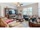 Cozy living room featuring a plush sofa, wooden furniture, and large windows at 120 Grove Branch Rd, Winter Haven, FL 33880