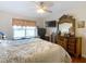 Main bedroom features a ceiling fan, TV, and decorative wood dresser with mirror at 120 Grove Branch Rd, Winter Haven, FL 33880