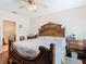 Main bedroom features a decorative wooden bed frame, hardwood floors, and attached bathroom at 120 Grove Branch Rd, Winter Haven, FL 33880