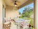 Covered patio area with elegant outdoor dining set and a tropical-themed fan at 120 Grove Branch Rd, Winter Haven, FL 33880