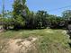 Land with scattered grass and trees in an overgrown backyard setting at 1208 Lowry Ave, Haines City, FL 33844
