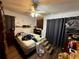 Bedroom with a ceiling fan, wood-look flooring, and an array of personal belongings at 1208 Lowry Ave, Haines City, FL 33844