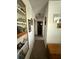 Hallway with tiled floors leading to multiple rooms, featuring a display cabinet and mirrors at 1208 Lowry Ave, Haines City, FL 33844