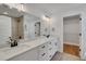 Bathroom featuring double vanity, black fixtures, a large mirror and a walk-in closet at 1242 Dorothy St, Lakeland, FL 33815
