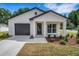 Charming single-story home featuring a black garage door and a well-manicured lawn at 1242 Dorothy St, Lakeland, FL 33815